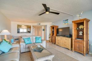 a living room with a couch and a tv at Clearwater Beachfront Condo with Heated Pool Access! in Clearwater Beach