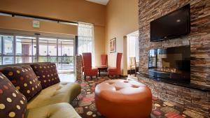 a living room with a couch and a fireplace at Best Western Luxbury Inn Fort Wayne in Fort Wayne