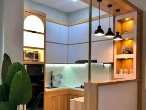 a kitchen with white cabinets and a large window at NG Shelter Homestay & Daycare in Karawang