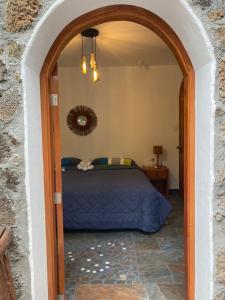 1 dormitorio con cama y puerta abovedada en La Fortaleza De Haro, en Puerto Ayora