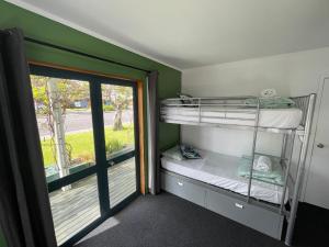 派西亚Peppertree Lodge的一间带双层床的卧室和通往阳台的门