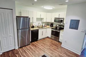 uma cozinha com armários brancos e um frigorífico de aço inoxidável em The Lofts on Clematis 402 Downtown West Palm Beach em West Palm Beach