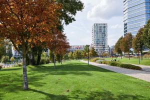 a park with green grass and trees and buildings at Radisson Hotel Budapest BudaPart in Budapest