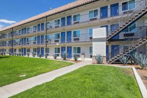 an apartment building with blue doors and a lawn at Suites Escondido CA in Escondido