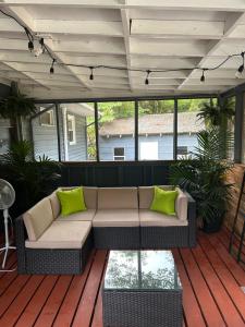 un sofá en una terraza con almohadas verdes en Serene Retreat! 3 minutes to downtown Richmond en Richmond