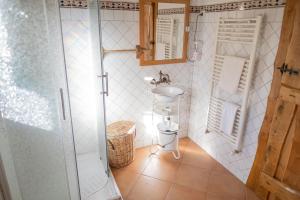 a small bathroom with a sink and a shower at Casa dos do Carvalho - Miradouro da Branda in Branda de Santo António