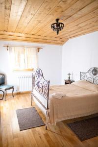a bedroom with a bed and a wooden ceiling at Casa dos do Carvalho - Miradouro da Branda in Branda de Santo António
