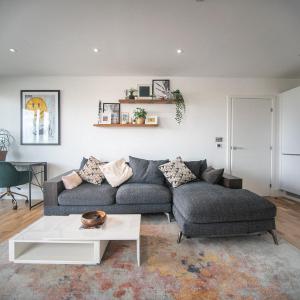 a living room with a couch and a table at Stunning Riverside View Apartment, near Canary Wharf & O2 in London