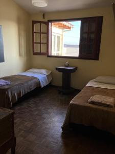 um quarto com 2 camas, um lavatório e uma janela em Luis marcelo em Alta Gracia