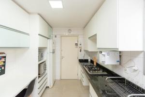 cocina con armarios blancos y encimera negra en Apartamento de 3 quartos no Setor Bueno - DLZ0302, en Goiânia