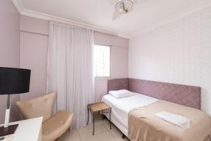 1 dormitorio con cama, escritorio y ventana en Apartamento de 3 quartos no Setor Bueno - DLZ0302, en Goiânia