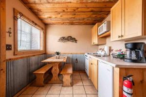 a kitchen with a wooden table and a small table at New! Charming Cabin in Colorado National Forest in Lake George