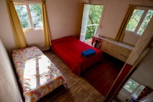 Habitación pequeña con 1 cama y 2 ventanas en El descanso en Villa Carlos Paz