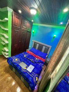 uma cama num quarto com uma parede azul e verde em Boston Luxry Furnished Appartments em Iaundé