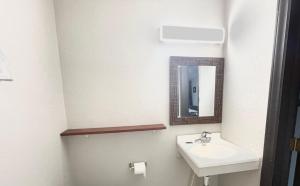 W łazience znajduje się umywalka i lustro. w obiekcie Azure Sky Motel w mieście Fort Scott