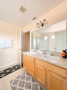 baño con 2 lavabos y espejo grande en Luxry villa 6 miles from Disney en Orlando