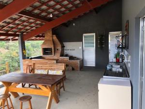 een keuken en eetkamer met een houten tafel bij Chácara Bela Vista in Paraibuna