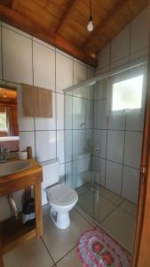 a bathroom with a toilet and a glass shower at Cabana no alto do morro in Nova Petrópolis