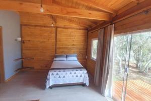 a bedroom with two beds in a room with a window at Cabana no alto do morro in Nova Petrópolis