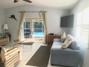 a living room with a couch and a sliding glass door at Del Mar Villa in Naples