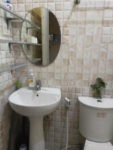 W łazience znajduje się umywalka, lustro i toaleta. w obiekcie La Residencia Tacloban w mieście Tacloban