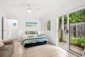 una camera da letto con un letto e una porta scorrevole in vetro di 11 Dalmor Court a Coolum Beach Altre 20 foto