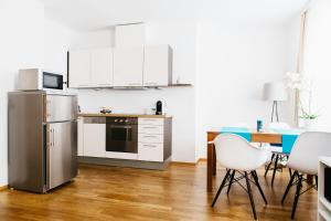 a kitchen with white cabinets and a table and chairs at Home Sweet Apartments - A cozy welcome in Vienna