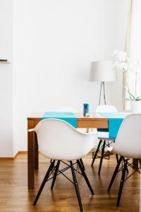 a dining room with two white chairs and a table at Home Sweet Apartments | contactless check-in in Vienna