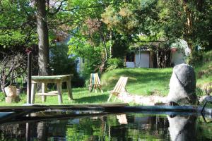 a picnic table and chairs next to a body of water at ChacraKremen in El Bolsón