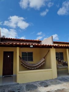 a yellow house with a red roof at Pousada Talismã in Barreirinhas