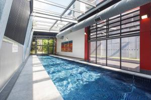 a swimming pool in a building with a large window at Urban Oasis in the Heart of Richmond Cultural Hub in Melbourne