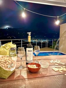a bottle of wine and two glasses on a table at Ruitoque Apartamento Campestre Maravillosa Vista in Floridablanca