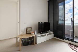 uma sala de estar com uma televisão e uma mesa em Light, Elevated Living near Queen Victoria Market em Melbourne