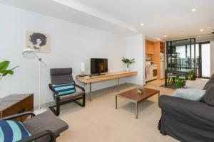 sala de estar con sofá, mesa y TV en Backpackers' Delight with Sprawling City Views en Melbourne