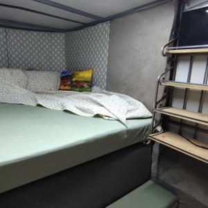 mały pokój z łóżkiem i telewizorem w obiekcie Trailer de Viagem no Rancho Santo Sol w mieście Pederneiras