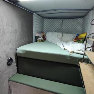 a small bedroom with a bed in a trailer at Trailer na Pousada Santo Sol in Pederneiras