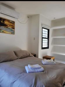 ein Schlafzimmer mit einem Bett mit zwei Handtüchern darauf in der Unterkunft Duplex Familiar in Yerba Buena