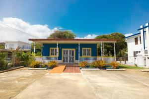 een blauw-wit huis met planten ervoor bij Jobos Beach Apt #1 near food truck and beach . in Isabela