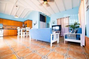 een woonkamer met een blauwe bank en een keuken bij Jobos Beach Apt #1 near food truck and beach . in Isabela