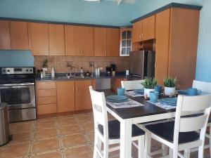 a kitchen with a table and chairs and a kitchen with brown cabinets at Jobos Beach Apt #1 near food truck and beach . in Isabela