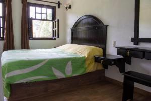 a bedroom with a bed with a green and yellow blanket at Finca Marix, Villa del Carbón in Villa del Carbón
