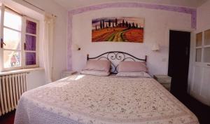 1 dormitorio con 1 cama con edredón blanco en Casale vita nova, en Manciano