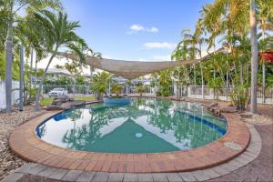 a pool with a hammock in a yard with palm trees at Discover a Scandi Style Pool Retreat in Nightcliff in Darwin