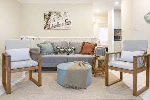 a living room with a couch and two chairs at Discover a Scandi Style Pool Retreat in Nightcliff in Darwin