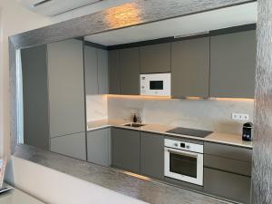 uma cozinha com armários cinzentos, um lavatório e um fogão em Doñana 1027 em Patalavaca