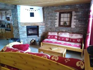ein Wohnzimmer mit einem Sofa und einem Kamin in der Unterkunft Chalet la Tuilière***** in Bonneval-sur-Arc