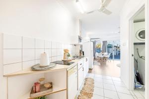 a kitchen with white appliances and a dining room at Cullen Bay Calm - Tropical Poolside Living in Larrakeyah