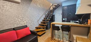 - un salon avec un canapé noir et un escalier dans l'établissement Loft Duplex NYC Berrini 1503, à São Paulo