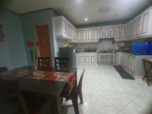 a kitchen with white cabinets and a table and chairs at La Residencia Tacloban in Tacloban