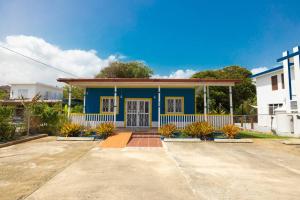 uma casa azul e branca com plantas à sua frente em Jobos Beach Apt #2 near food truck and beach em Isabela